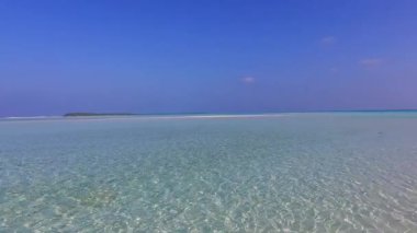 Turkuaz okyanus ve palmiyelerin yakınındaki temiz kum arka planıyla deniz kıyısı sahillerinde güneşli bir yolculuk.