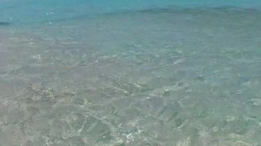 Deniz turistleri için deniz manzaralı plaj tatili, su mavisi lagün ve resifin yakınındaki beyaz kumlu arka plan.