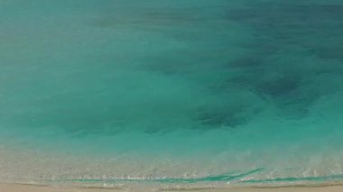 Turkuaz okyanus ve palmiyelerin yakınındaki beyaz kum arka planının oluşturduğu lüks koy sahili yaşam tarzının gündüz manzarası.