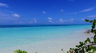 Cennet kıyısındaki gökyüzünü kapatın. Mavi okyanus kıyısındaki vahşi yaşam ve resifin yakınındaki beyaz kumlu arka plan.