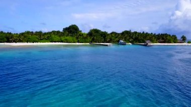 Turkuaz lagünün, dalgaların yanında beyaz kum arka planlı lüks lagünün geniş açı dokusu.