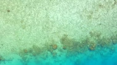 Deniz kıyısının boş dokusu, dalgalara yakın beyaz kumlu arka planlı mavi okyanus bayramı.