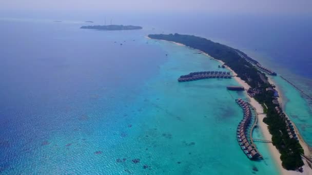 Weitwinkelkulisse idyllischer Lagunenstrandabenteuer durch blaues Meer und weißen Sandhintergrund im Sonnenlicht — Stockvideo