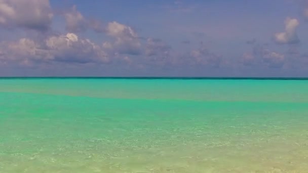 Крупним планом море спокійного курортного пляжного відпочинку на мілководді з білим піщаним фоном біля піщаної панелі — стокове відео
