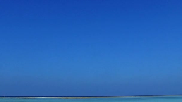 Paisagem de ângulo largo de tranquila praia costeira viagem pelo mar azul do aqua e fundo arenoso branco perto de recife — Vídeo de Stock