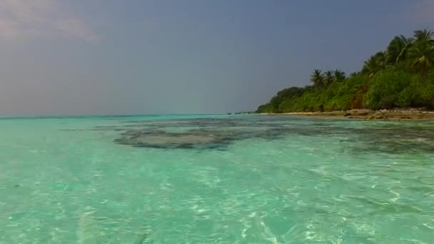 砂浜の近くに白い砂浜の背景を持つ青い水で牧歌的なリゾートビーチの航海の空の風景 — ストック動画