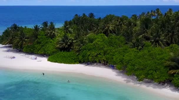Mavi okyanus kıyısındaki sakin tatil beldesinin güneşli manzarası ve dalgaların yakınındaki parlak kumlu arka plan — Stok video