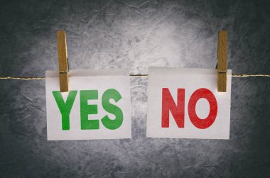 Koyu arka plan üzerinde elbise pimleri iple Evet ve hiçbir kağıt not ekleme