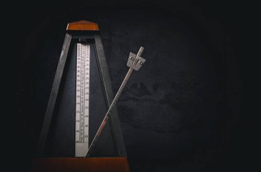 Vintage metronom koyu arka plan üzerinde. Düşük anahtar görüntü.