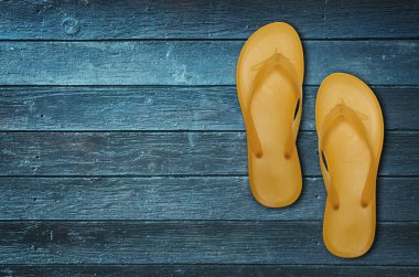 Mavi ahşap zemin üzerine parlak parmak arası terlik