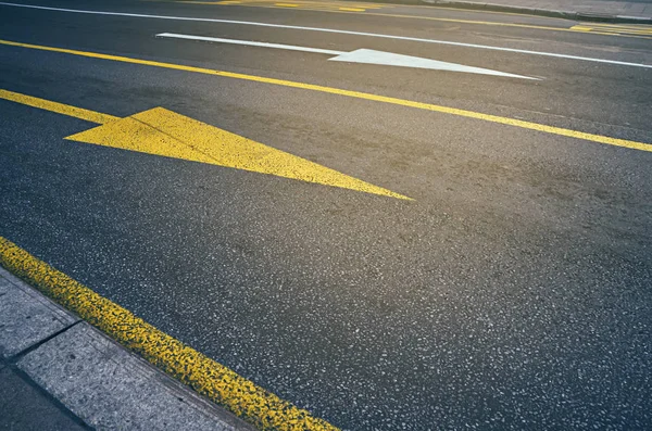 Flecha amarela e branca na estrada. Tráfego urbano . — Fotografia de Stock