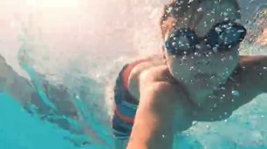 Yüzme havuzunda sualtı genç çocuk eğlence. Yaz tatili eğlenceli.