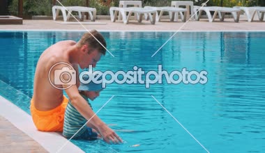 Yüzme havuzunda lüks resort yakınında oturan iki çocuk