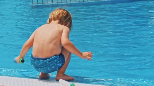Ευτυχισμένος Μικρό Αγόρι Κάθεται Κοντά Στην Πισίνα — Αρχείο Βίντεο
