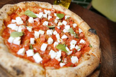 Ağız sulandıran yakın plan bir tablo üzerinde oturan taze pişmiş pizzanın büyüleyici malzemelerini ve altın kabuğunu gözler önüne seriyor..