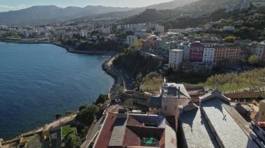 Korsika şehir manzarasının bir su kütlesinin yanında yer aldığını gösteren hava perspektifi.