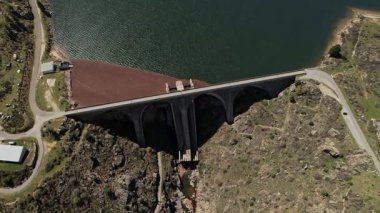 Fransa, Korsika 'da nehir boyunca uzanan bir köprünün kuş bakışı görüntüsü, aşağıdaki sakin suyun üzerindeki mimari başarıyı gözler önüne seriyor..