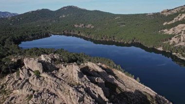 Korsika 'nın yüksek dağları arasında yuva yapmış büyük bir su kütlesi, açık gökyüzünün altında..