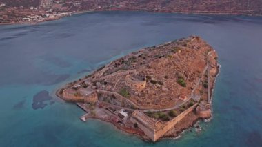 Spinalonga Adası Yunanistan 'ın Girit kentindeki altın saat boyunca doğa ve mimarinin çarpıcı bir karışımı olan berrak sularla çevrili tarihi kalesini sergiliyor.