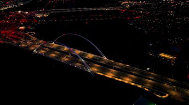 Margaret McDermott Köprüsü 'nün iki kemeri Dallas' taki ünlü Buluşma Kulesi 'ni çerçeveliyor.