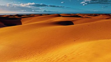 Havadan bakıldığında, İspanya, Gran Canaria 'nın engin altın kum tepecikleri, canlı bir gökyüzünün altında, bu eşsiz manzaranın doğal güzelliğini vurguluyor..