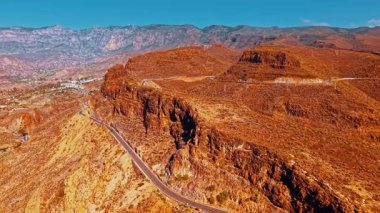İnsansız hava aracı Gran Canaria 'nın çarpıcı kurak manzarasını yakalıyor, dramatik uçurumlar ve dolambaçlı yollar açık mavi bir gökyüzü altında adanın doğal güzelliğini vurguluyor..