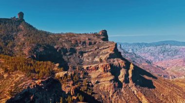 Gran Canaria 'nın dramatik manzaralarını keşfedin. İspanya' da güneşli bir günde engebeli dağlar ve açık mavi bir gökyüzü altında canlı yeşillikler sergiliyorsunuz..