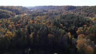 Renkli sonbahar yaprakları, turuncu, sarı ve yeşilin canlı gölgeleriyle vadiyi kaplıyor. Huzurlu manzaranın çarpıcı bir görüntüsünü oluşturuyor..