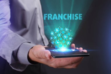 İş, teknoloji, Internet ve ağ kavramı. Geleceğin sanal bir ekranda çalışan genç bir girişimci ve yazıt görür: Franchise