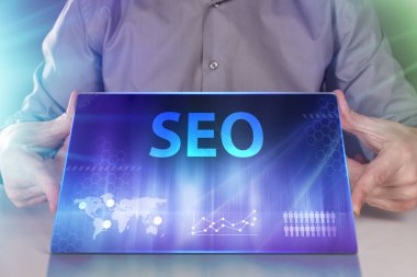 İş, teknoloji, Internet ve ağ kavramı. Geleceğin sanal bir ekranda çalışan genç bir girişimci ve yazıt görür: Seo