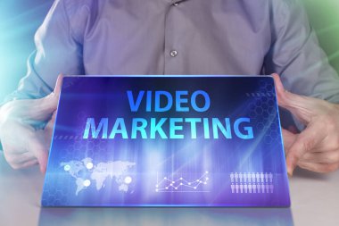 İş, teknoloji, Internet ve ağ kavramı. Geleceğin sanal bir ekranda çalışan genç bir girişimci ve yazıt görür: Video pazarlama