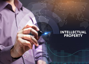 İş, teknoloji, internet ve şebeke kavramı. Genç bir girişimci geleceğin sanal ekranı üzerinde çalışıyor ve yazıyı görüyor: fikri mülkiyet