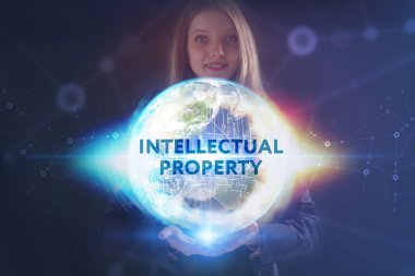 İş, teknoloji, internet ve şebeke kavramı. Genç bir girişimci geleceğin sanal ekranı üzerinde çalışıyor ve yazıyı görüyor: fikri mülkiyet