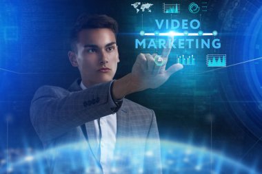 İş, teknoloji, Internet ve ağ kavramı. Geleceğin sanal bir ekranda çalışan genç bir girişimci ve yazıt görür: Video pazarlama