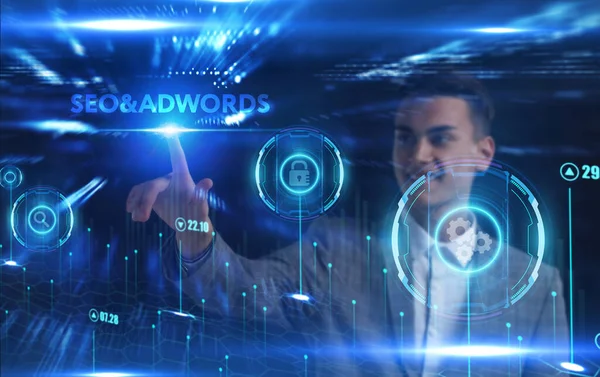 İş, Teknoloji, İnternet ve ağ konsepti. Genç işadamı geleceğin sanal ekranı üzerinde çalışıyor ve yazıyı görüyor: SEO & Adwords