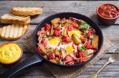 Sahanda yumurta sosis, patates ve sebze ile