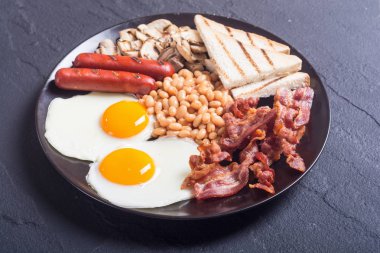 Yumurta mantar, fasulye, sosis ve domuz pastırması İngiliz kahvaltısı