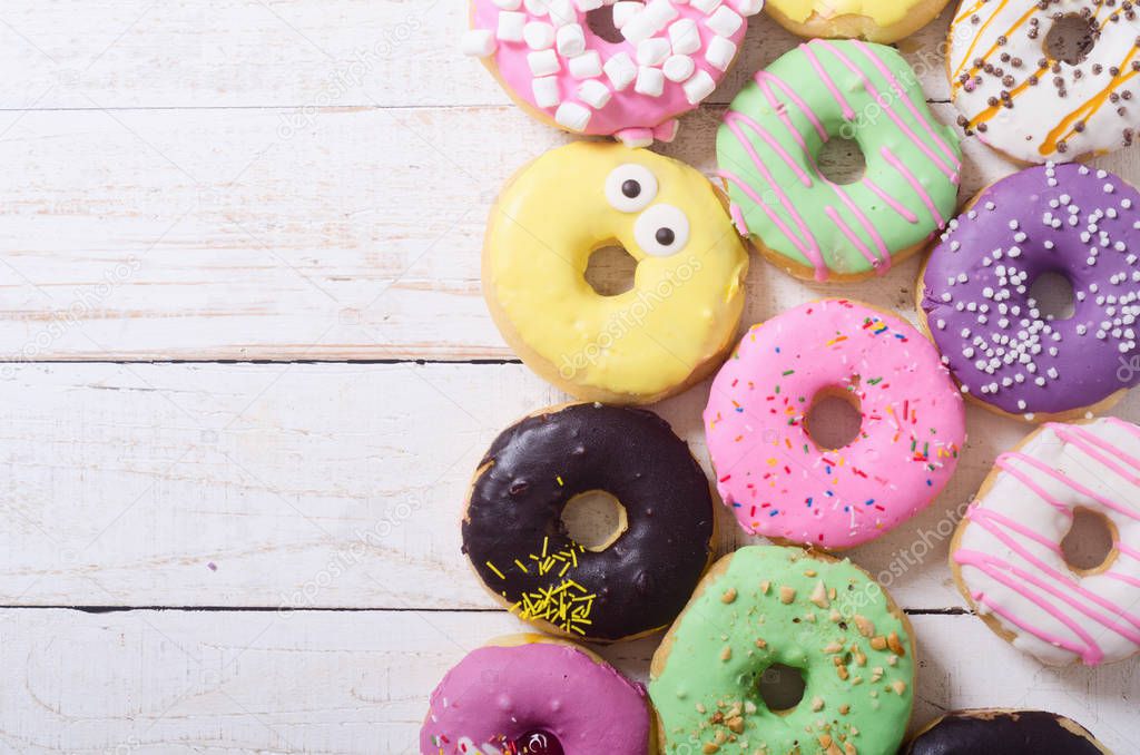 assorted donuts with chocolate frosted, pink glazed and sprinkles . Top view 