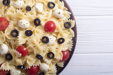 Mozzarella peyniri, zeytin ve domates ile makarna salatası. İtalyan yemeği arka plan