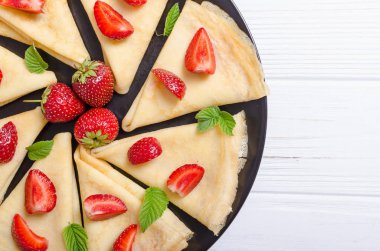 Ev yapımı Rus krep rustik arka plan üzerinde çilek ile