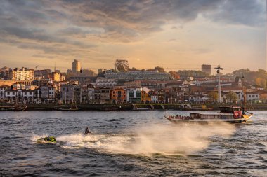 Porto, Porugal -13 Kasım 2021: Ribeira bölgesinin mimarisi ve Douro Nehri 'nden görünen turistler için bir tekne