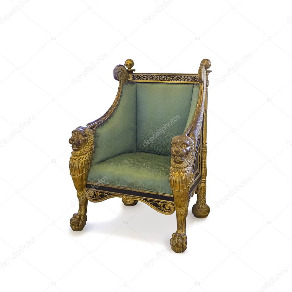 Ancient golden armchair decorated with winged lions isolated on white background