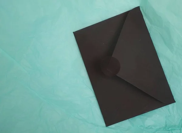 Romantic composition with black envelopes on a turquoise background