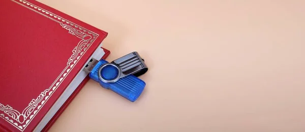 Book and memory card isolated on pink background