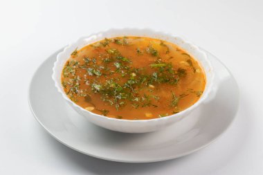 Beyaz bir tabakta taze dereotlu tavuk çorbası.