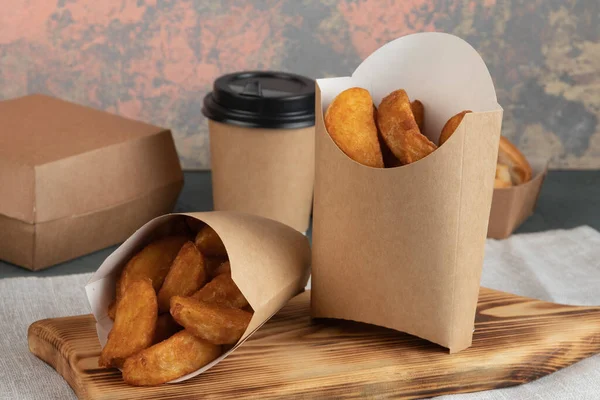 Eco packaging - potato wedges in craft packaging for delivery service. Vegan food.