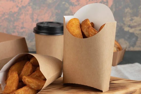 Eco packaging - potato wedges in craft packaging for delivery service. Vegan food.