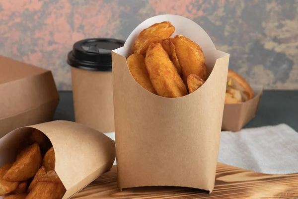 Eco packaging - potato wedges in craft packaging for delivery service. Vegan food.