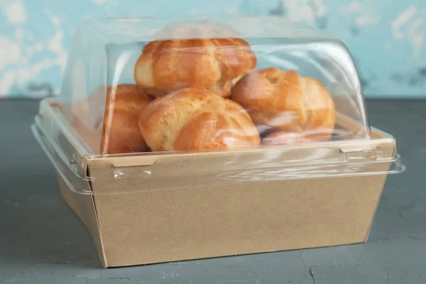 Eco packaging - profiteroles with cream in craft packaging for the delivery service.