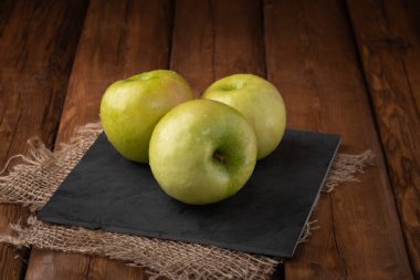 Çevre meyveleri - ahşap arka planda taze yeşil elma, vejetaryen yiyecekler